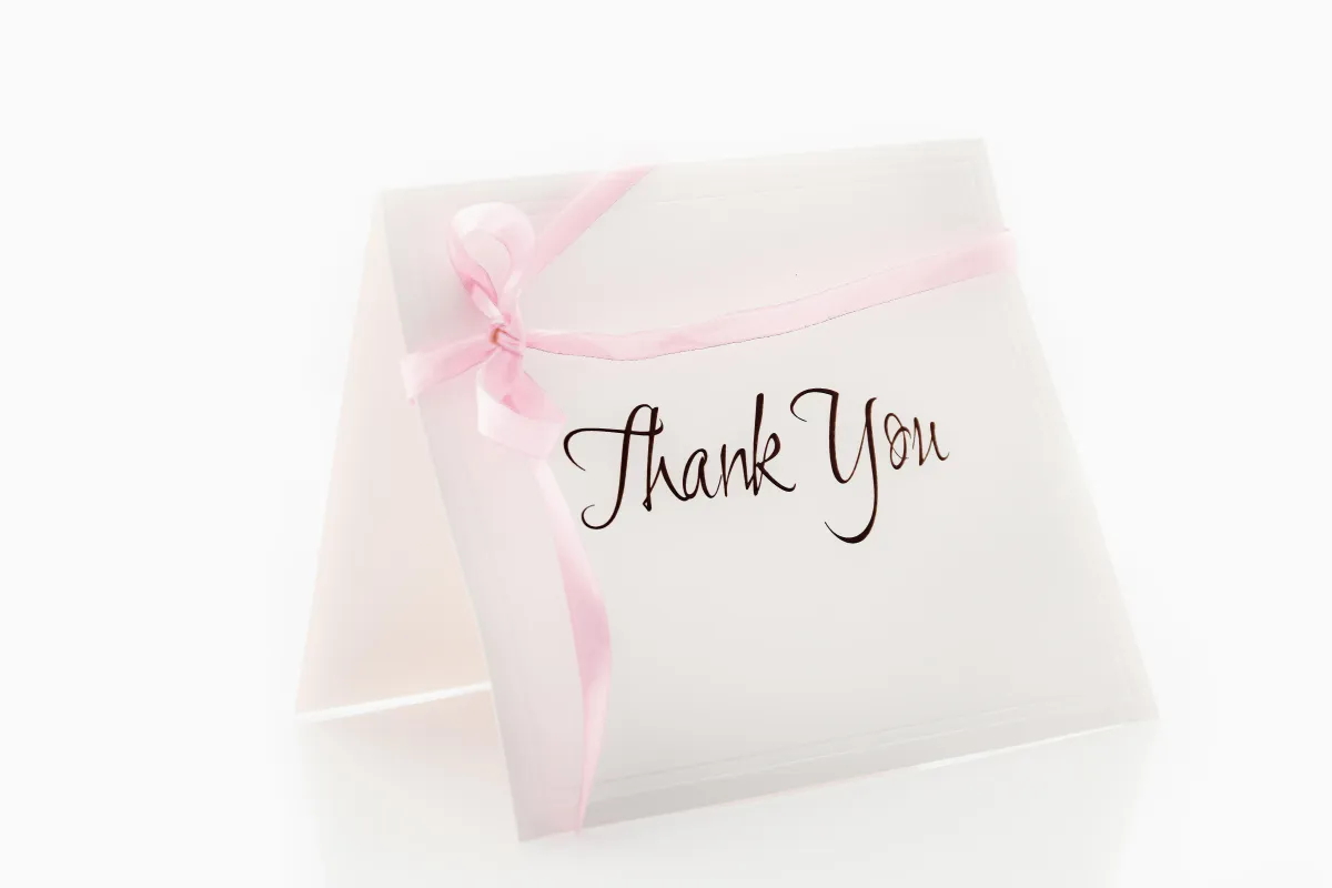 Cartão de agradecimento com laço rosa e a mensagem 'Thank You' escrita em fonte cursiva, ideal para expressar gratidão